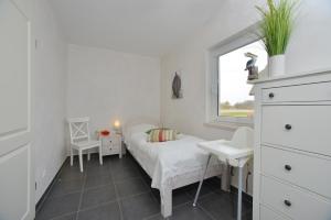 ein kleines Schlafzimmer mit einem Bett und einem Fenster in der Unterkunft Ferienhaus Boddenblick in Breege
