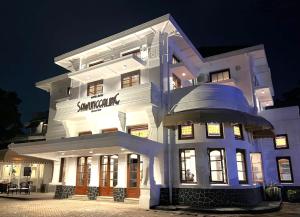 a large white building with a sign on it at night at Hotel Butik Sawunggaling in Bandung