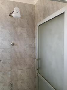 BungomaMiranda suites的浴室里带玻璃门的淋浴间