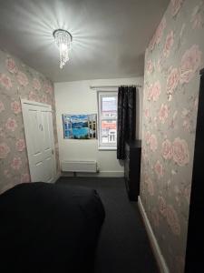een slaapkamer met roze rozen aan de muur bij Homey room in Liverpool