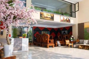 a lobby with chairs and a tree with pink flowers at Quỳnh Vy Hotel Thái Nguyên in Thái Nguyên