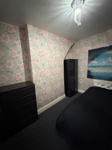 een slaapkamer met roze bloemen aan de muur bij Homey room in Liverpool