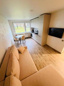 een woonkamer met een bank en een tafel bij Ūla Apartments in Mažeikiai