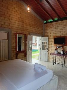 een slaapkamer met een wit bed in een bakstenen muur bij Galle Light Villa in Galle +41 foto's