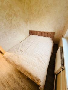 een kleine slaapkamer met een bed in de hoek bij Ūla Apartments in Mažeikiai