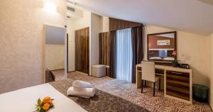 a hotel room with a desk and a mirror at Hotel Terra Nova in Novalja