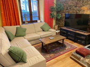 un soggiorno con due divani e una televisione di Casa Rural MONTE ROBLO a Salamón