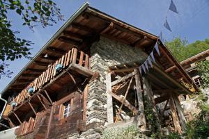 a house with a wooden balcony on top of it at Lieu Secret dans les Alpes Suisses in Le Trétien