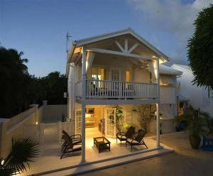 ein Haus mit einer Terrasse mit Stühlen in der Unterkunft Mango Court 1 - by ZenBreak in Saint James