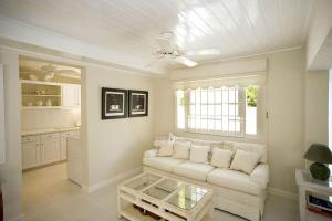 ein Wohnzimmer mit einer weißen Couch und einem Fenster in der Unterkunft Mango Court 1 - by ZenBreak in Saint James