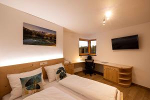 een slaapkamer met een bed en een bureau met een computer bij Sirona Stay - Private Spa Retreat with garden, garage and Bolzano-Card in San Genesio Atesino