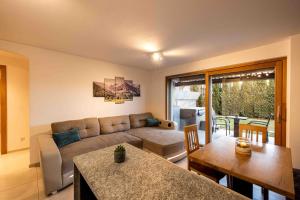 een woonkamer met een bank en een tafel bij Sirona Stay - Private Spa Retreat with garden, garage and Bolzano-Card in San Genesio Atesino