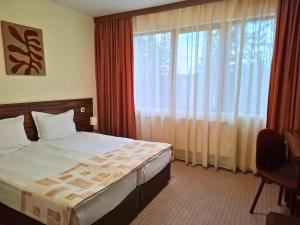ein Hotelzimmer mit einem Bett und einem großen Fenster in der Unterkunft Elina Hotel in Pamporowo