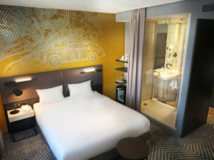 una camera da letto con un letto bianco e un bagno di Mercure Warszawa Grand a Varsavia Altre 193 foto