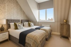 En eller flere senge i et værelse på Harrogates Most Central Apartments - Sleeps 12