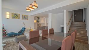a dining room and living room with a table and chairs at Chambres Mountain in Poiana Brasov