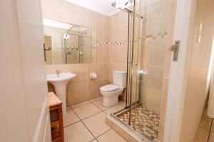 een badkamer met een douche, een toilet en een wastafel bij The Pelican in Langebaan +23 foto's