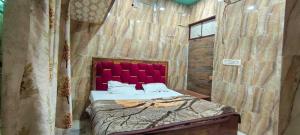 una camera con letto con testiera rossa di Hotel O new A.p galaxy a Juhi Bari