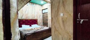 una piccola camera con un letto su una parete in legno di Hotel O new A.p galaxy a Juhi Bari