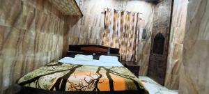 una camera da letto con un letto in un muro di pietra di Hotel O new A.p galaxy a Juhi Bari