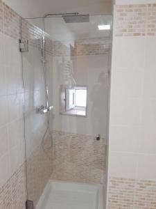 a bathroom with a shower with a glass door at Spacious white scandidesign in Ostuni +52 photos