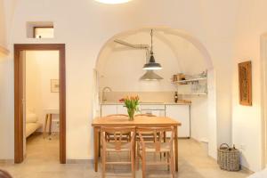 a kitchen and dining room with a table and chairs at Spacious white scandidesign in Ostuni