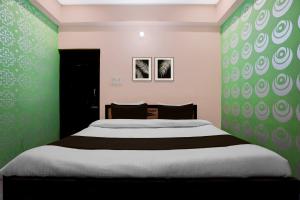 een slaapkamer met een groot bed met groene muren bij SPOT ON Hotel Brocode in Dānāpur