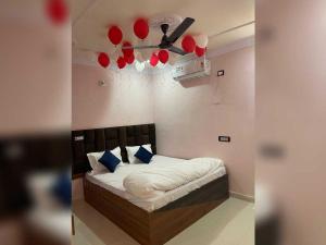 a bedroom with a bed with a ceiling fan and red balloons at Hotel O Downtown Rooms & Banquet in Darbhanga