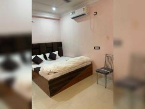 a bedroom with a bed and a chair in a room at Hotel O Downtown Rooms & Banquet in Darbhanga