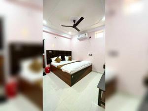a bedroom with a bed and a ceiling fan at Hotel O Downtown Rooms & Banquet in Darbhanga