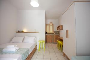 a bedroom with a bed and a yellow stool at Irene Studios in Agios Petros