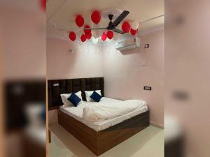 a bedroom with a bed with a ceiling fan and red balloons at Hotel O Downtown Rooms & Banquet in Darbhanga