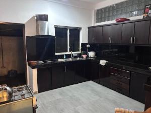 una cocina con armarios de madera oscura y una ventana en A&J Rest House, 