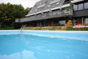 une grande piscine en face d'un bâtiment dans l'établissement Hostel De Veurs, à Sint-Martens-Voeren