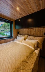a large bed in a room with a window at Flåm Minisuite in Aurland