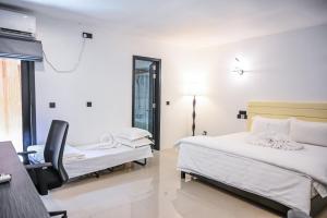 una camera da letto con due letti e una sedia di Oak Villa, Ukulhas a Ukulhas