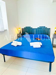 ein blaues Bett mit Handtüchern darüber in der Unterkunft Violetta 1 in Campese