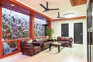 un soggiorno con mobili in pelle e ampie finestre di Oak Villa, Ukulhas a Ukulhas
