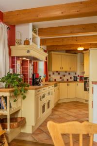 a large kitchen with white cabinets and wooden ceilings at Vitalhof Roithinger in Grieskirchen