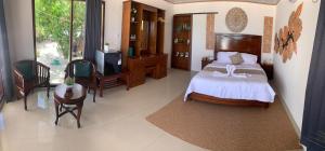 una camera da letto con un letto, un tavolo e delle sedie di Theresia Bin Cottage a Ngurblut