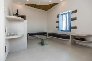 a white room with a bench and a window at Plaka Suites in Plaka Milou
