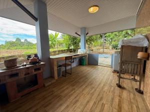 een keuken met een aanrecht en een tafel in een kamer bij Lanna Maple House in Ban Thap Dua