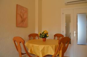 une table à manger avec une nappe et des chaises jaunes dans l'établissement Verdemar 6708 - Resort Choice, à Playa Honda