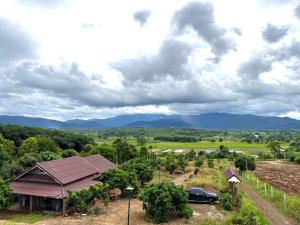 een uitzicht op een huis met bergen op de achtergrond bij Lanna Maple House in Ban Thap Dua