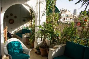 فندق حورس هاوس الزمالك في القاهرة: شرفة مع كراسي زرقاء ونباتات على مبنى
