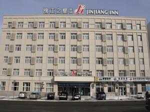a large building with cars parked in front of it at Jinjiang Inn Changchun Pepole Square in Changchun