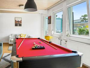 ein Billardtisch in einem Wohnzimmer mit einem roten Tisch in der Unterkunft Stuttgart Sky & Comfort Apartments in Stuttgart