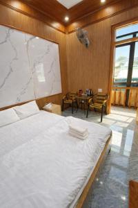 a bedroom with a large bed and a table with chairs at Hà Châu Homestay in Mù Cang Chải +35 photos