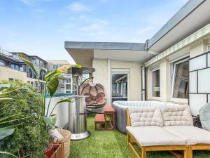 eine Außenterrasse mit einem Sofa und einem Tisch in der Unterkunft Stuttgart Sky & Comfort Apartments in Stuttgart