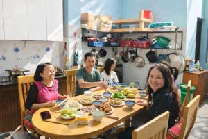 a group of people sitting around a table eating food at Hà Châu Homestay in Mù Cang Chải